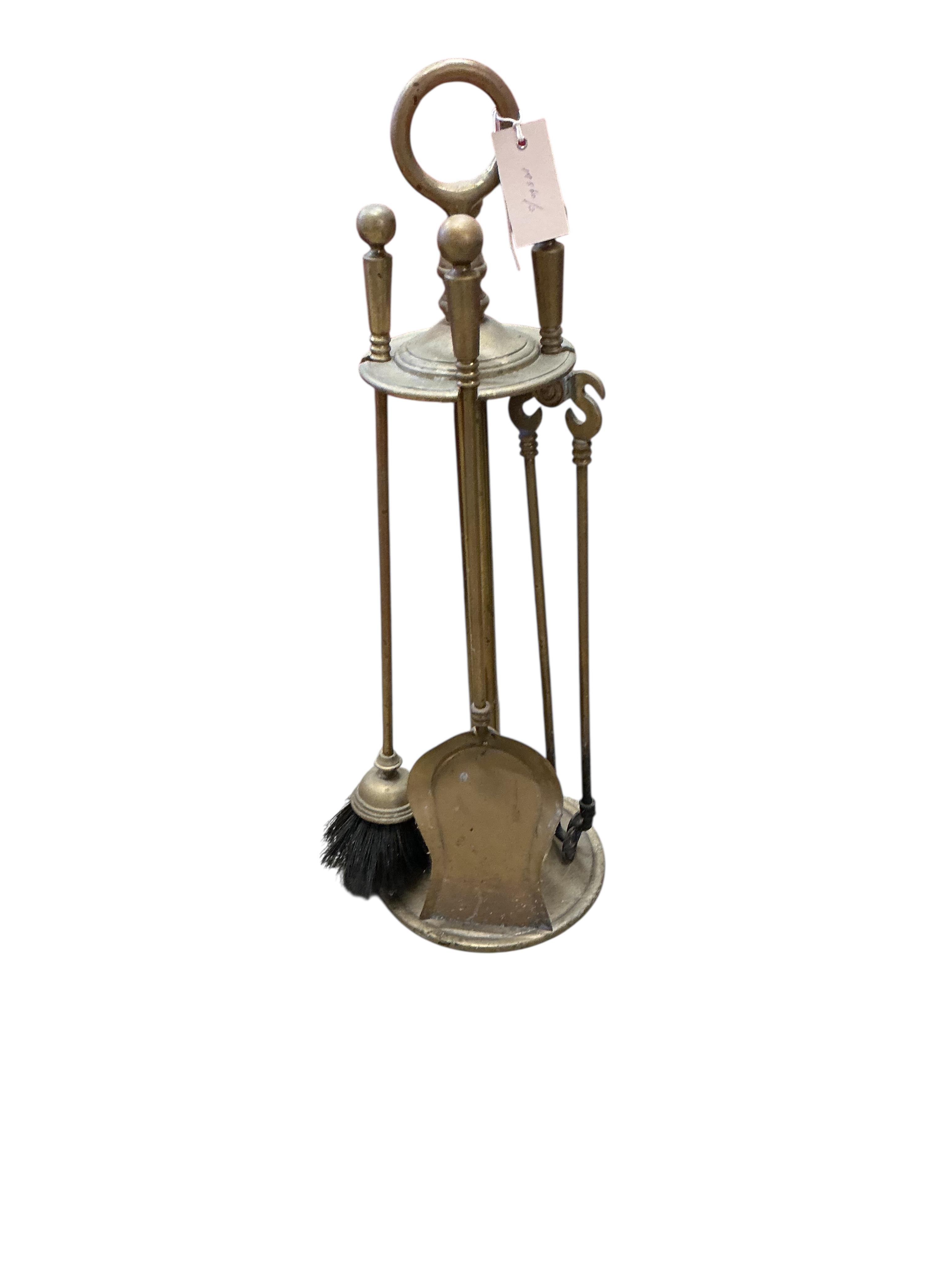 A brass four piece fire implement set, height 65cm